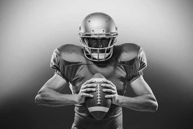 American football player in red jersey and helmet holding ball