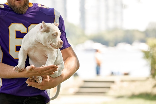 American football player with a dog posing on camera in a park copy space sports banner concept