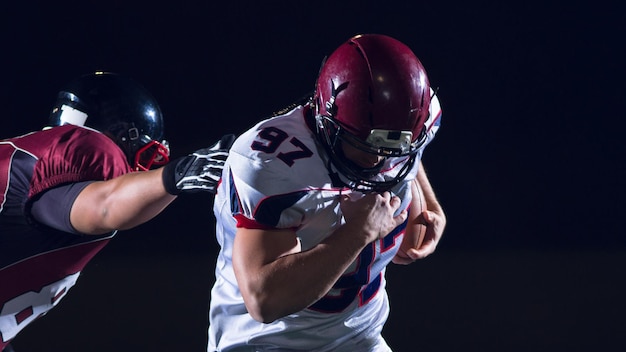 American football players in action at night game time on the field