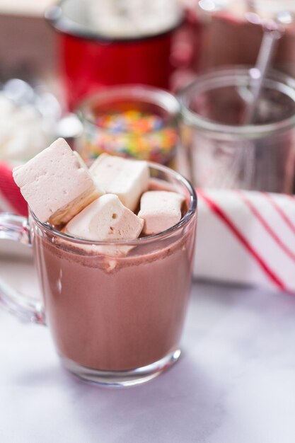 American hot chocolate topped with large marshmallow in glass cup.