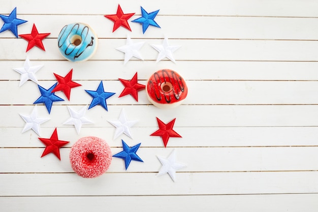 American independence day holidays concept Donut in disposable tableware and stars at 4th july party on wooden background