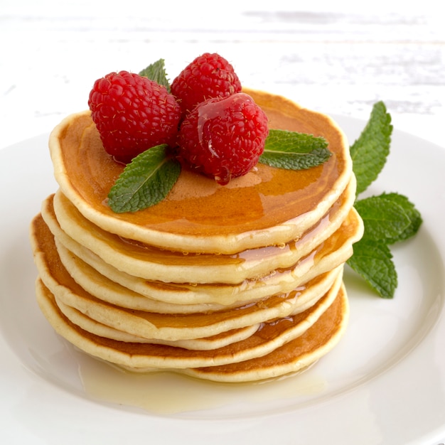 American pancakes with berries on a light background.