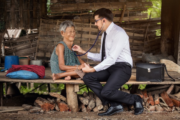 American physician examines elderly Asian patients using a hearing aid.