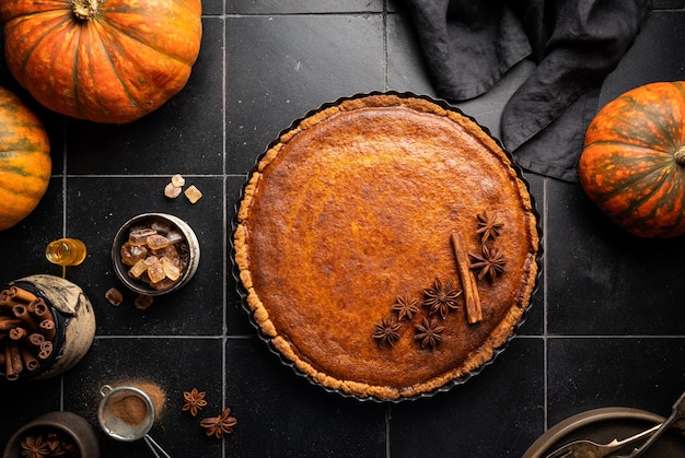 American pumpkin pie with cinnamon on dark background top view