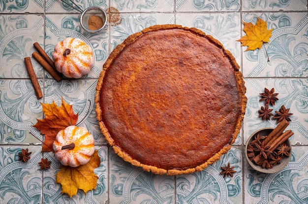 American pumpkin pie with cinnamon on tile background top view