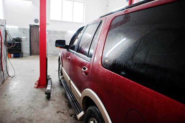 American SUV car on stand for wheels alignment camber check in workshop of service station