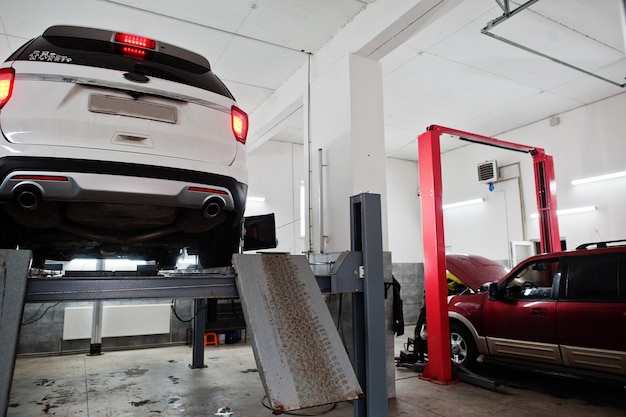 American SUV car on stand for wheels alignment camber check in workshop of service station