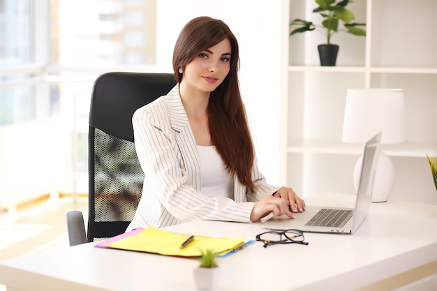 American woman working laptop. Business woman busy working on laptop computer in the office.