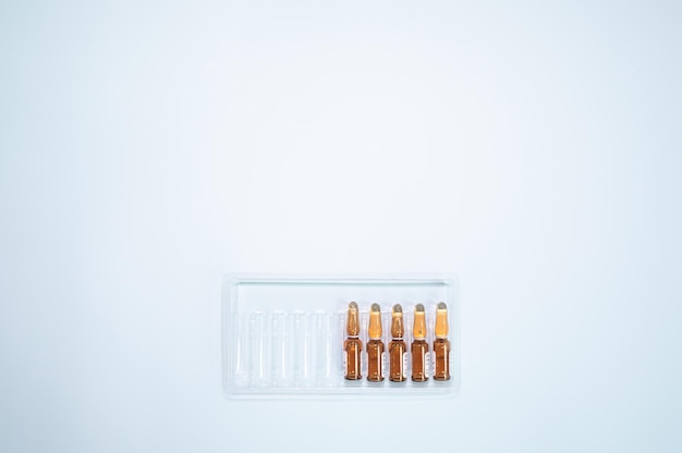 Ampoules with medicine on a blue background. Vaccination, injections, medicine.