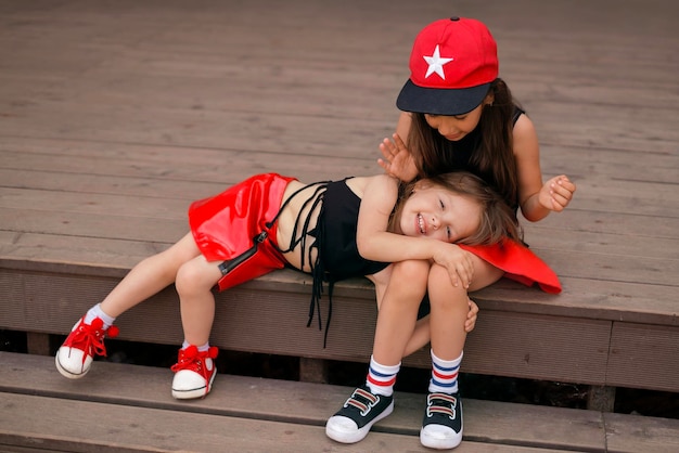 A amusing little laughing girl is lying on sister's lap