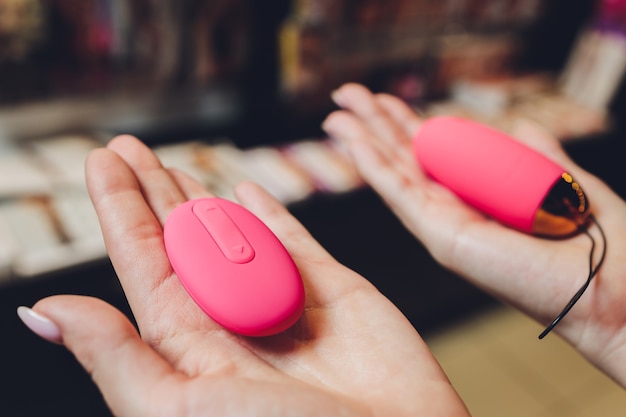 Anal plug with a fluffy pink tail with female hands. Toy for adult games.