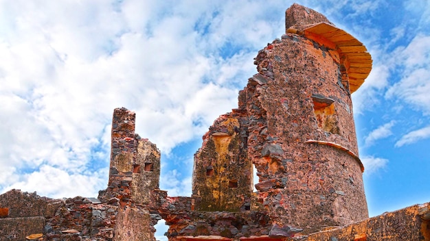 Ancient fort monuments of 16 th centuary in the ruins pieces with white clouds background