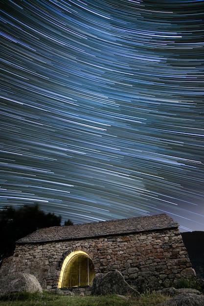 Ancient hermitage under star trails sky at night