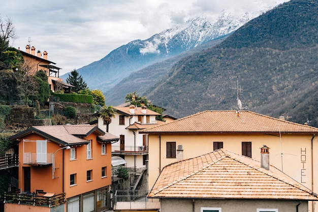 Ancient houses with tiled roofs against the backdrop of mountains lake como italy