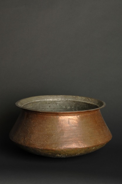 Ancient metal bowl on dark background. antique bronze tableware