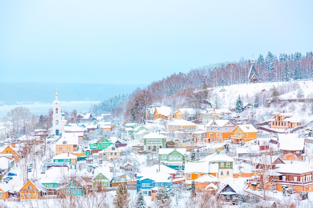 Ancient russian town Ples with old wooden colorful houses on the Volga river in winter with snow Ivanovo region Russia