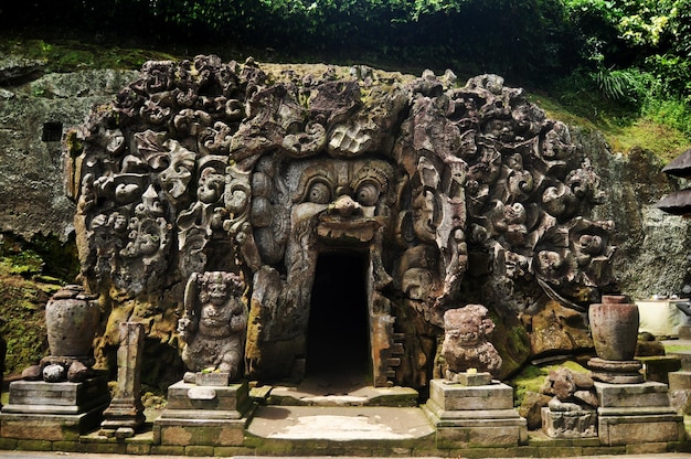 Ancient sculpture carving gate entrance tunnel of Goa Gajah or Elephant Cave significant Hindu archaeological site for travelers people travel visit and respect praying at Ubud city in Bali Indonesia