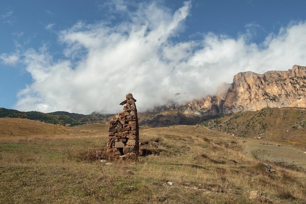 An ancient stone idol on the background of misty mountains Tombstones made of stone SturDigora region North Ossetia