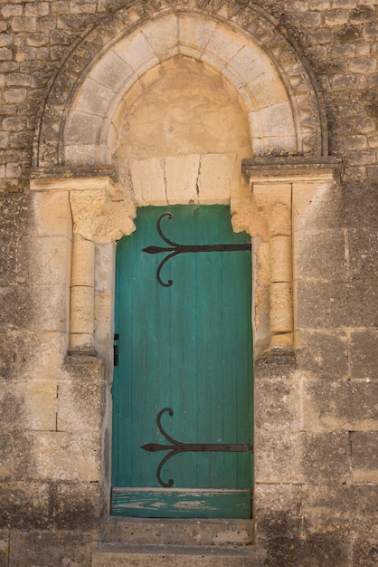 Ancient wooden green door in stone castle wall