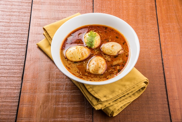 Anda Curry or Egg masala gravy, indian spicy food or recipe, served with Jeera Rice,roti or naan, selective focus. Over colourful or wooden table top