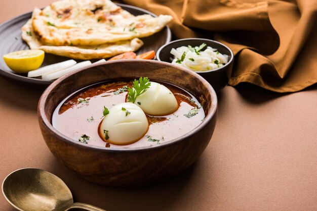 Anda Curry or Egg masala gravy, indian spicy food or recipe, served with roti or naan, selective focus