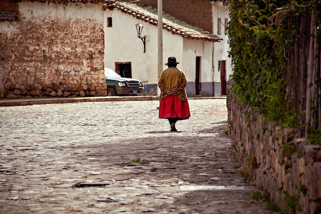 Andean woman walking down a street in a town