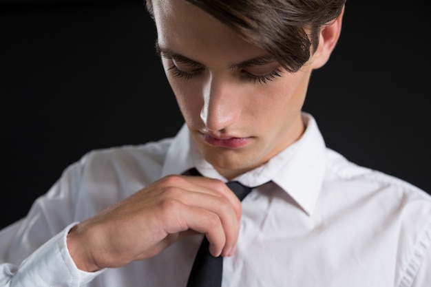 Androgynous man adjusting his tie