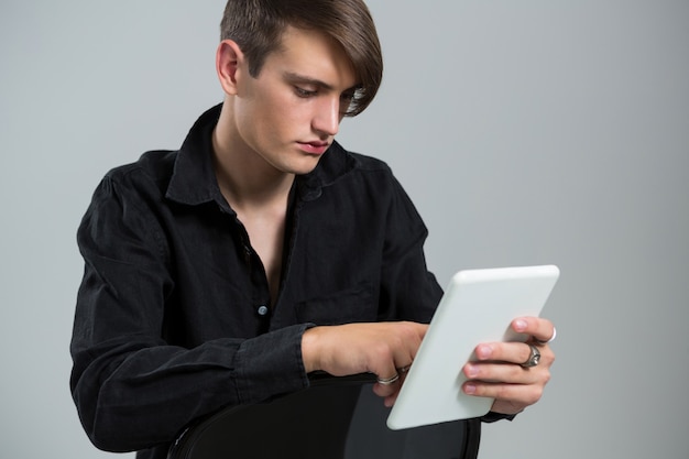 Androgynous man using digital tablet