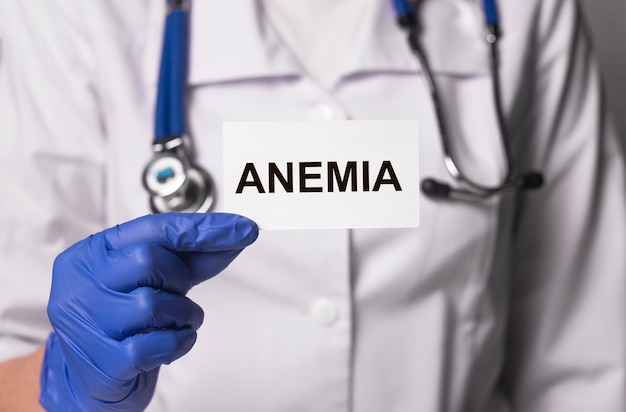 Anemia word on paper in doctor hand in gloves