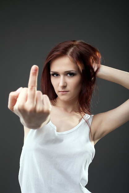 Anger young woman in tank top with fuck sign