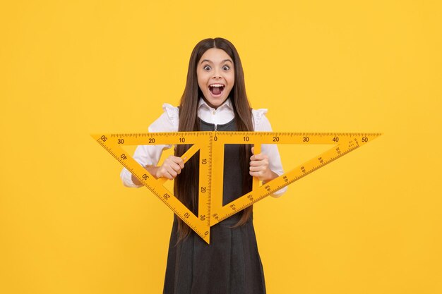 Photo angle degree measurement. surprised teen girl hold ruler. back to school. algebra and geometry. kid study math. trigonometry stationery. mathematics knowledge. education. child with triangle.