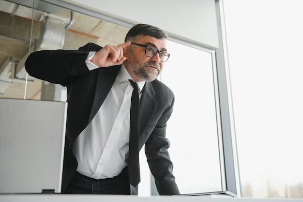 Angry businessman sitting at the table and screaming over