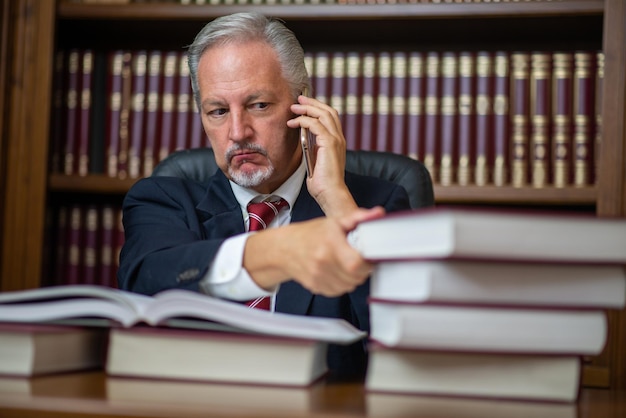 Photo angry businessman talking on the cellphone and reading a book