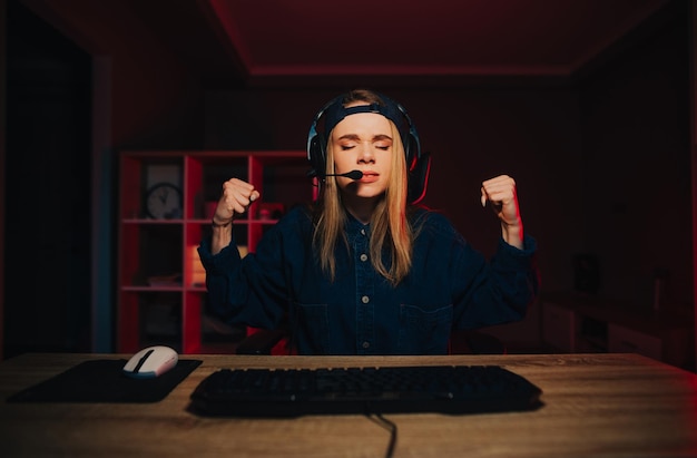 angry girl gamer gets angry after losing an online game on the computer at night with closed eyes