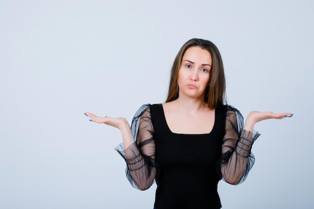 Angry girl is looking at camera by opening wide her hands on white background