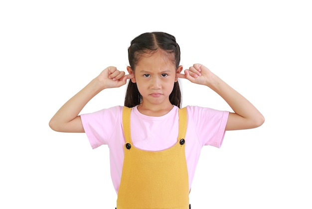 Angry kid close plug ears scream loudly tired by noisy sound, furious angry. Annoyed Asian little girl isolated on white background. Child avoid ignore unbearable loud noise ask quiet