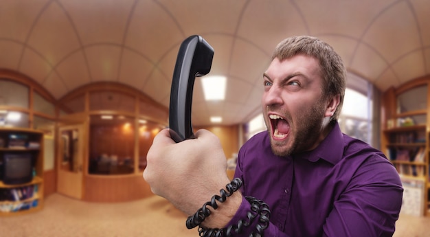 Angry man speaks on the phone