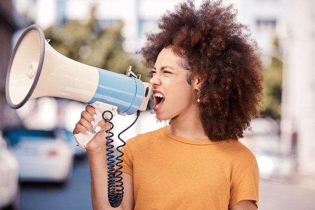 Angry megaphone and black woman talking at a protest for human rights in city of Iran Shouting frustrated and African girl with a microphone for an announcement at a riot for justice in the street