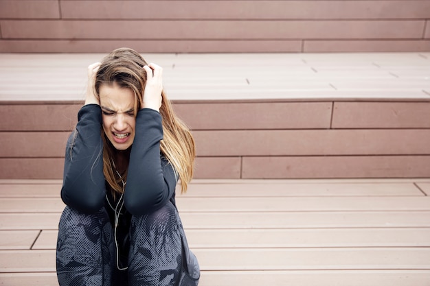 Angry sad young woman sitting outdoor