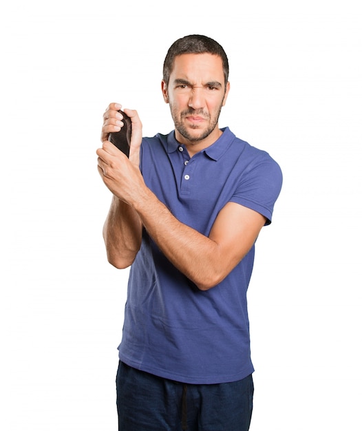 Angry young man holding a mobile phone on white background