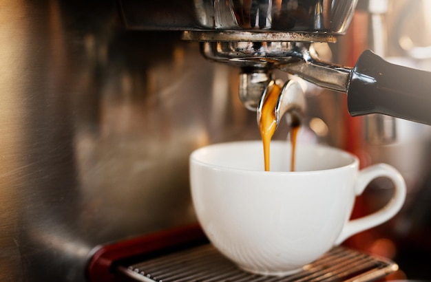 Another one thank you Closeup shot of an espresso maker pouring coffee into a cup inside of a cafe