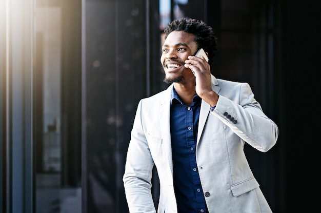 Another piece of positive news Cropped shot of a young businessman using his cellphone on the office balcony