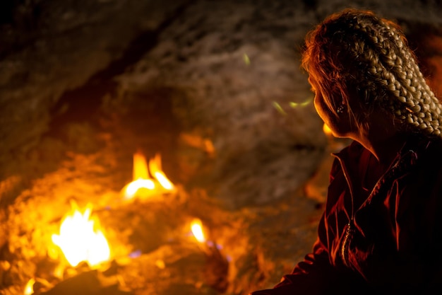 Antalya Province, Turkey - November 09, 2021: female tourist at night rest next to small fires on Mount Chimaera (Yanartas)