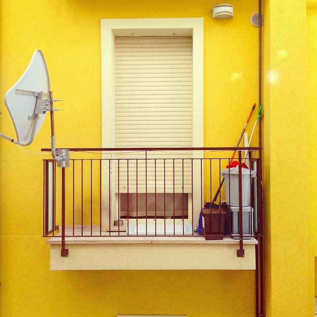 Photo antenna dish in balcony of yellow building