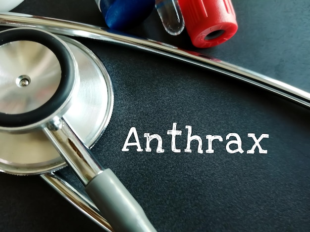 Anthrax medical term word with medical concepts on blackboard and medical equipment