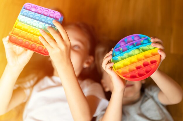 Anti stress sensory pop it toys in a children's hands. a little happy kids plays with a simple dimple toy at home. . flare