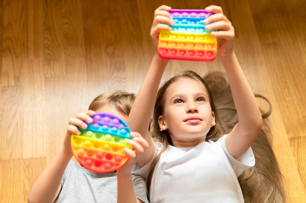 Anti stress sensory pop it toys in a children's hands. a little happy kids plays with a simple dimple toy at home. 