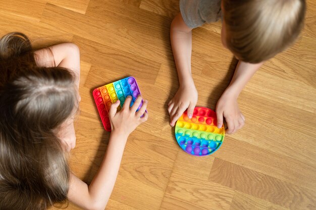 Anti stress sensory pop it toys in a children's hands. a little happy kids plays with a simple dimple toy at home. 