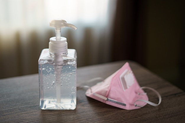 Antibacterial transparent hand sanitizer gel in a plastic bottle with surgical mask