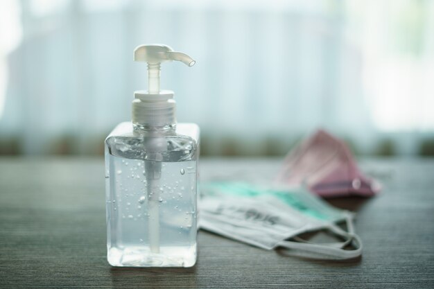 Antibacterial transparent hand sanitizer gel in a plastic bottle with surgical mask